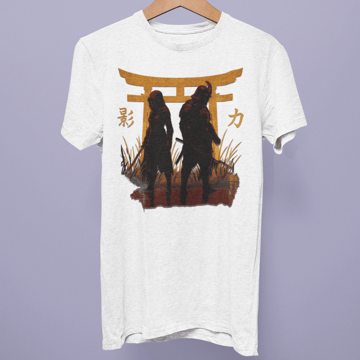Front view of the Assassin’s Creed Shadows Collection T-shirt on a hanger, showing two shadowed figures under a golden torii gate on white fabric.