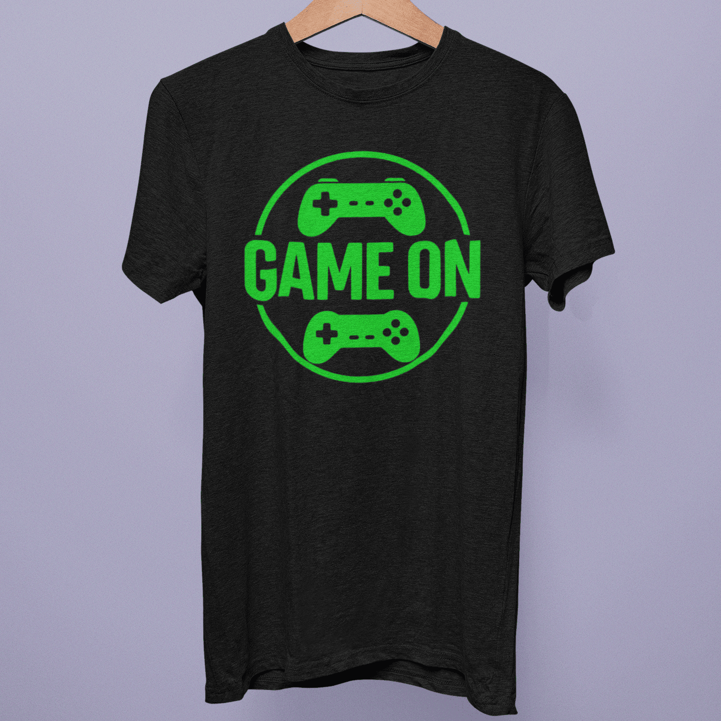 Front view of the Gamer Lifestyle Collection T-shirt on a hanger, showing green “Game On” controller artwork on black fabric.