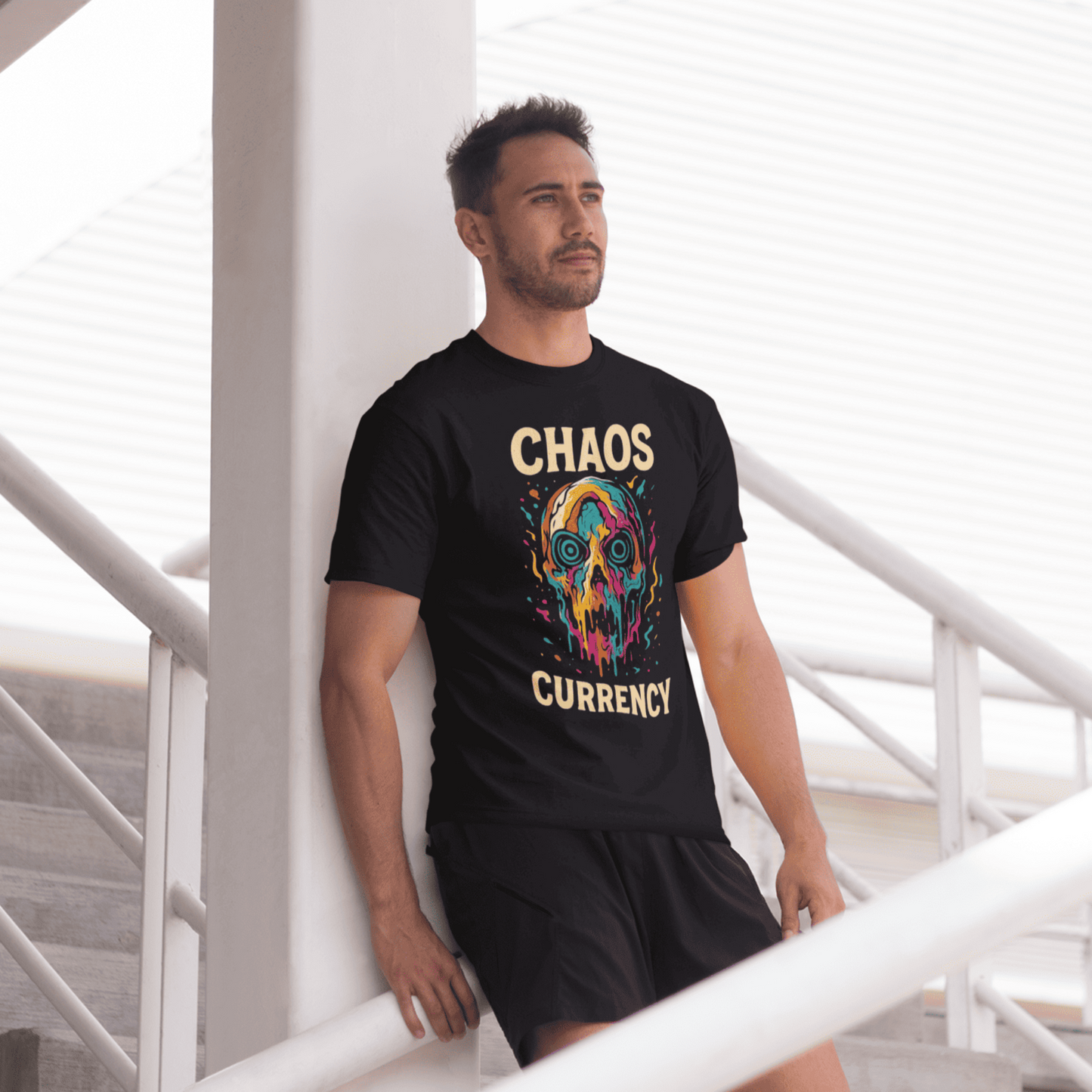 Man wearing a black t-shirt with colorful graphic and text, standing in a modern indoor setting.