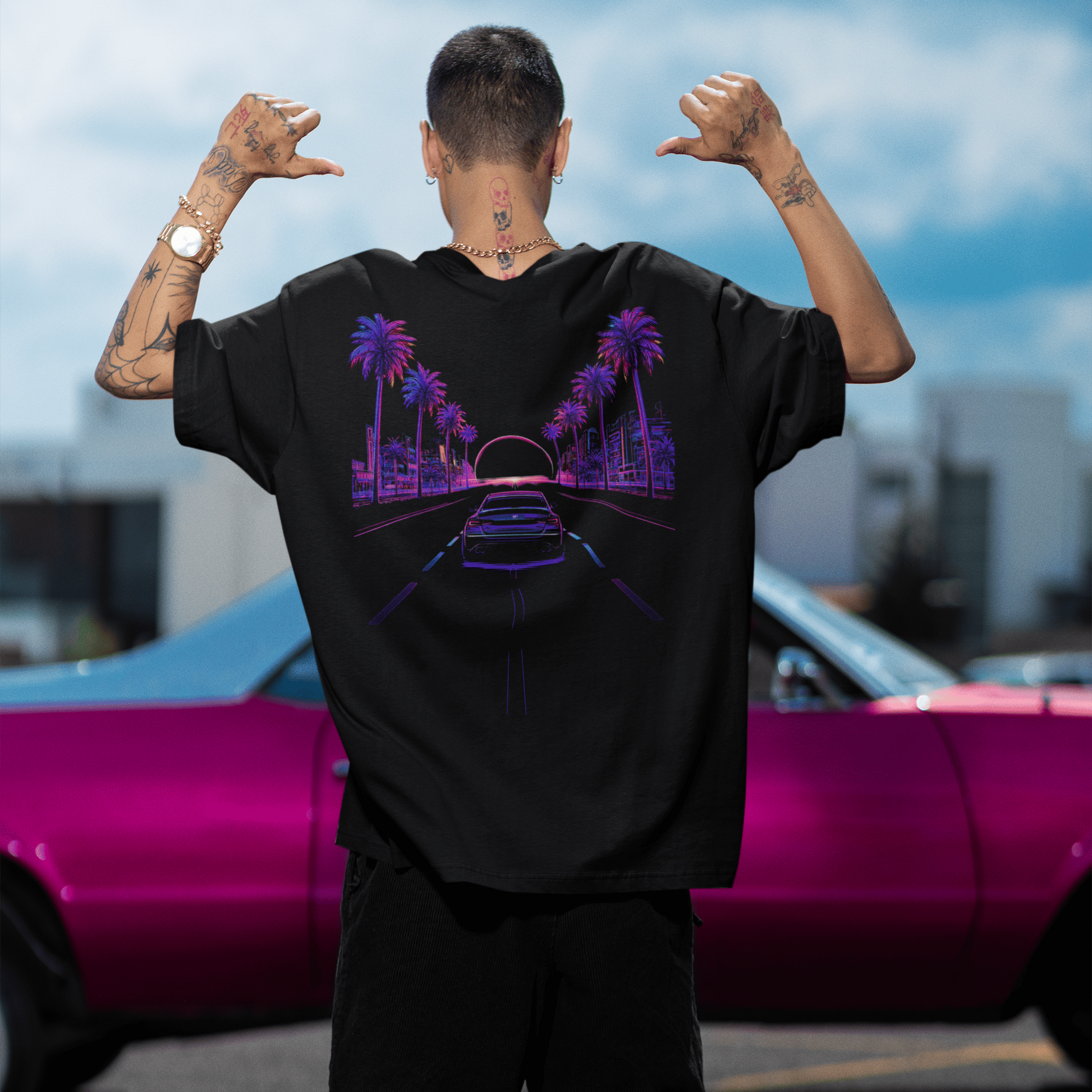 Person wearing a black t-shirt with a colorful graphic design outdoors.