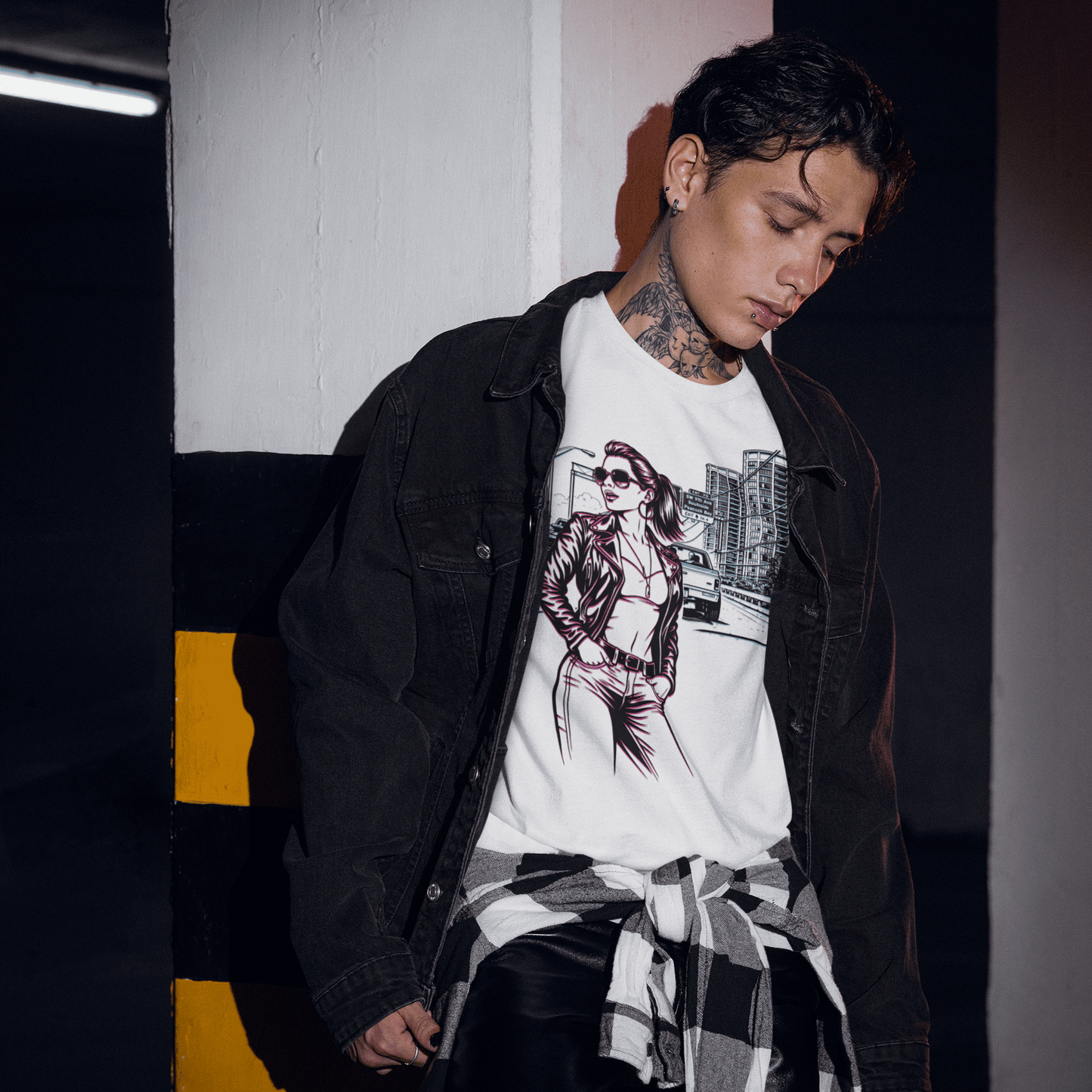 Person wearing a white graphic t-shirt and black jacket in an urban setting