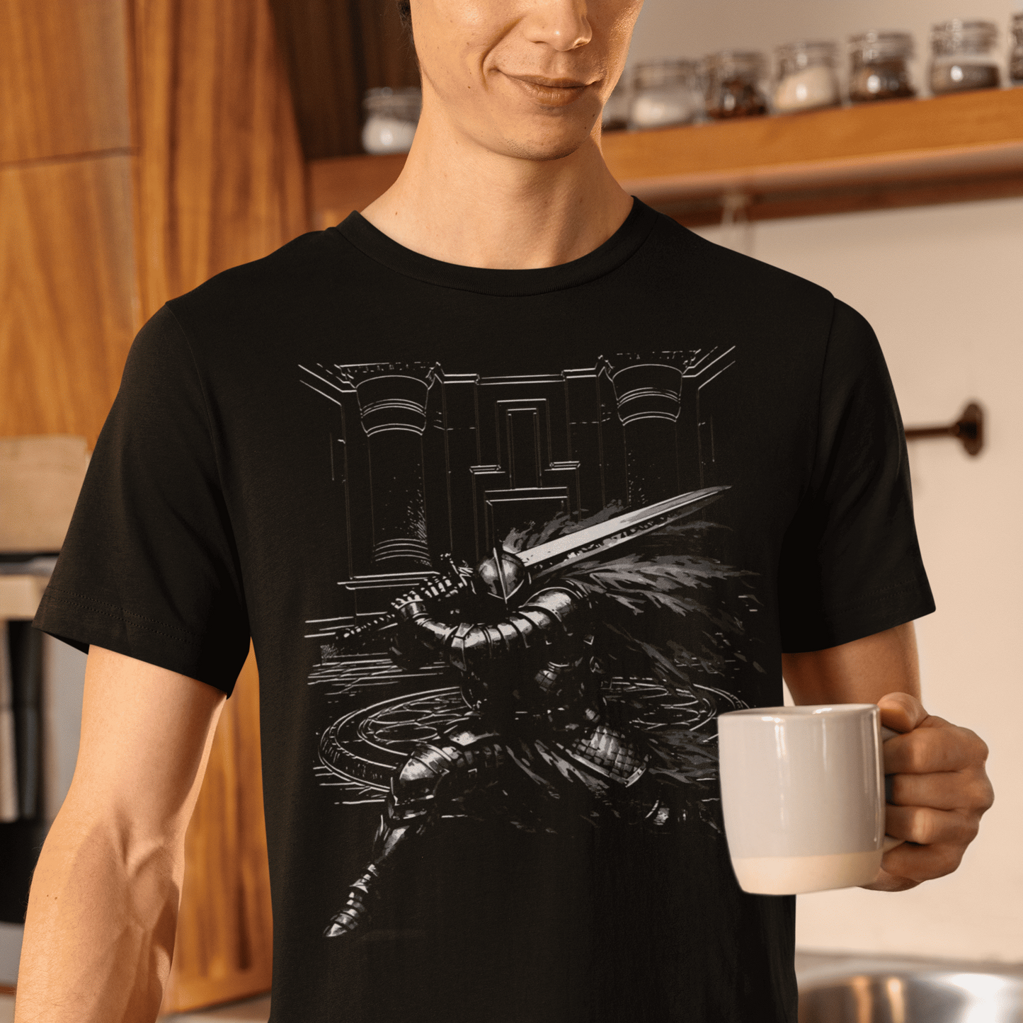 Person wearing a black t-shirt with a graphic design, holding a white mug in a kitchen.