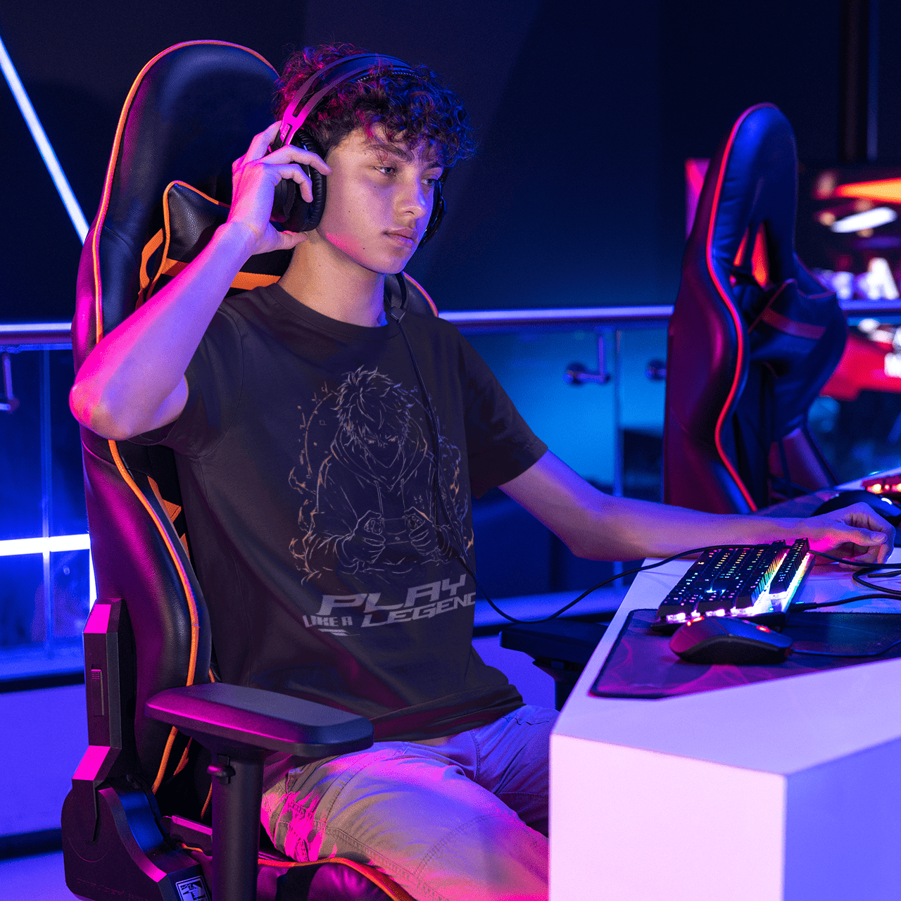Lifestyle view of Play Like a Legend Gamer T-Shirt – Anime Player Mode worn at a neon gaming setup