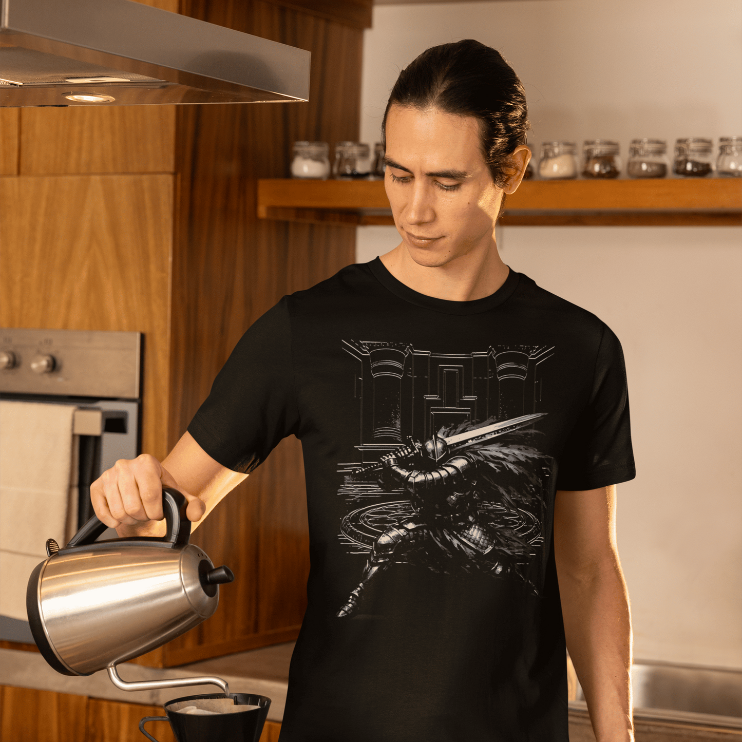 Person pouring coffee in a kitchen wearing a black t-shirt with a graphic design.