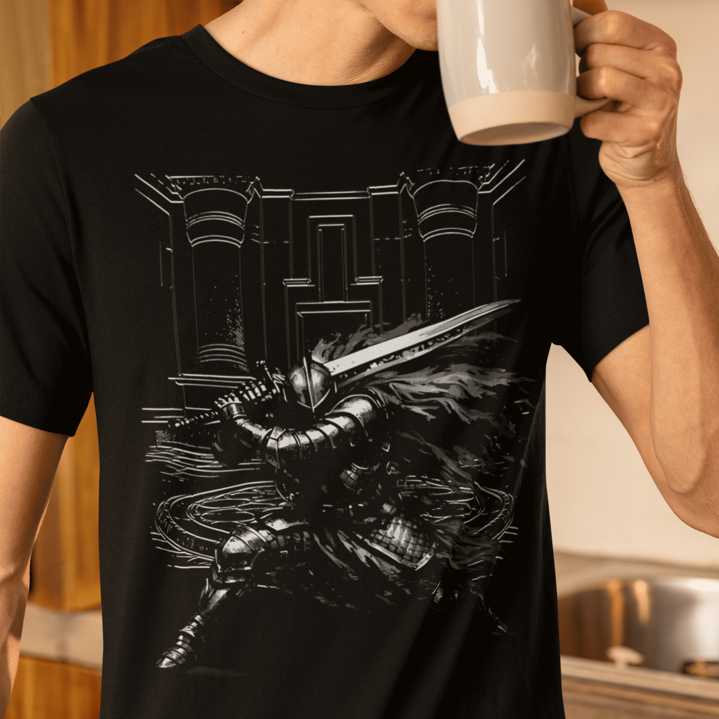 Person wearing a black t-shirt with a graphic design, holding a white mug in a kitchen.
