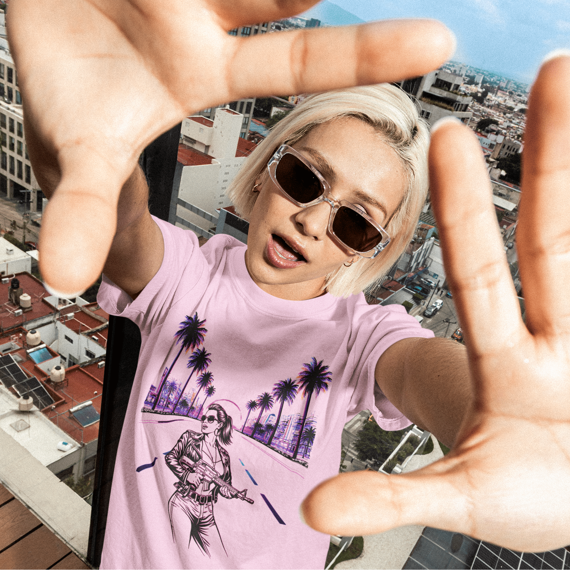Model wearing the light pink GTA Open Road Control Tee inspired by Grand Theft Auto VI featuring open road graphic design, standing on a rooftop with a cityscape background