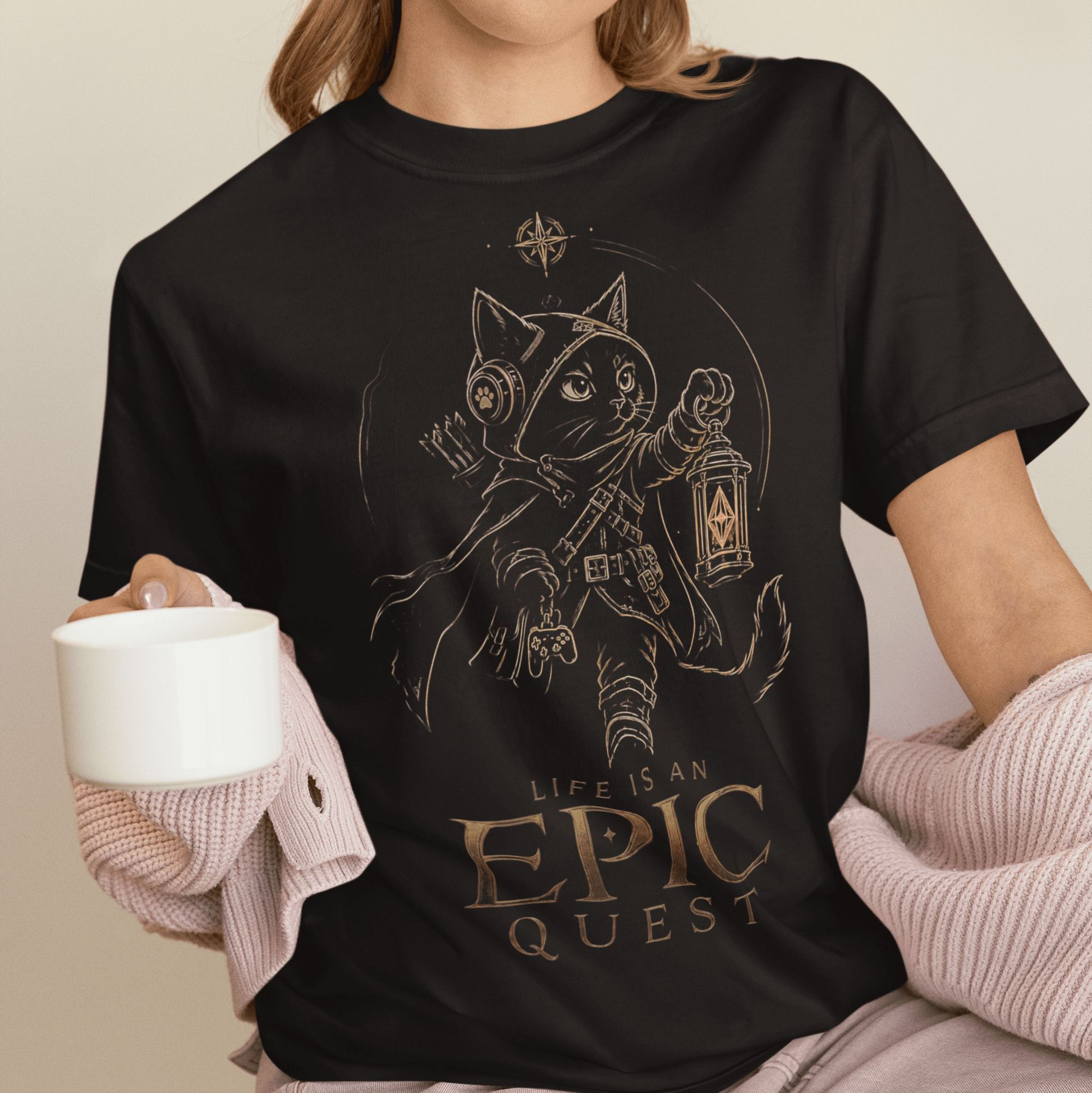 Cozy seated view of Life Is an Epic Quest Gamer T-Shirt with Adventure Cat Art worn while holding a drink