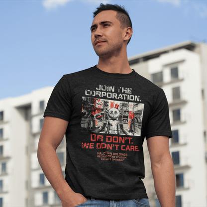 Man wearing a black t-shirt with graphic design and text, standing outdoors with buildings in the background