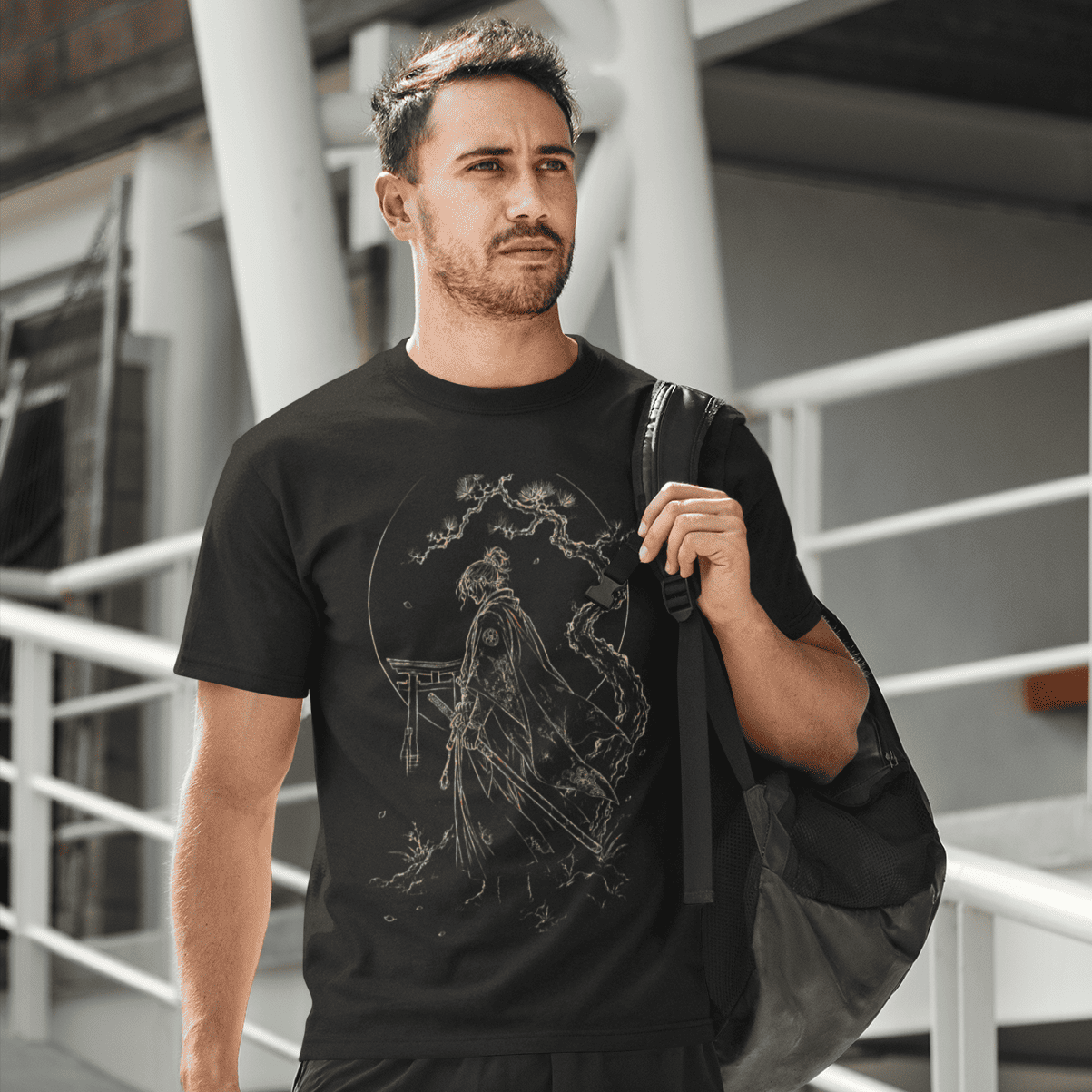 Male model in Torii Samurai T-Shirt with warrior gate artwork beside modern urban architecture.
