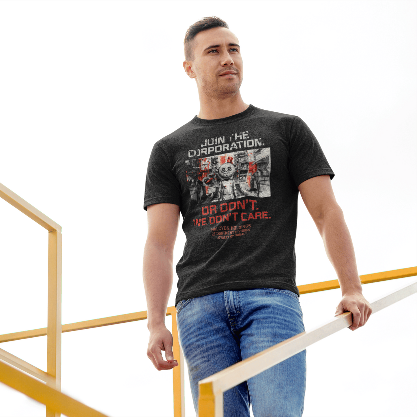 Man wearing a black t-shirt with graphic design and text, standing on a yellow metal staircase.
