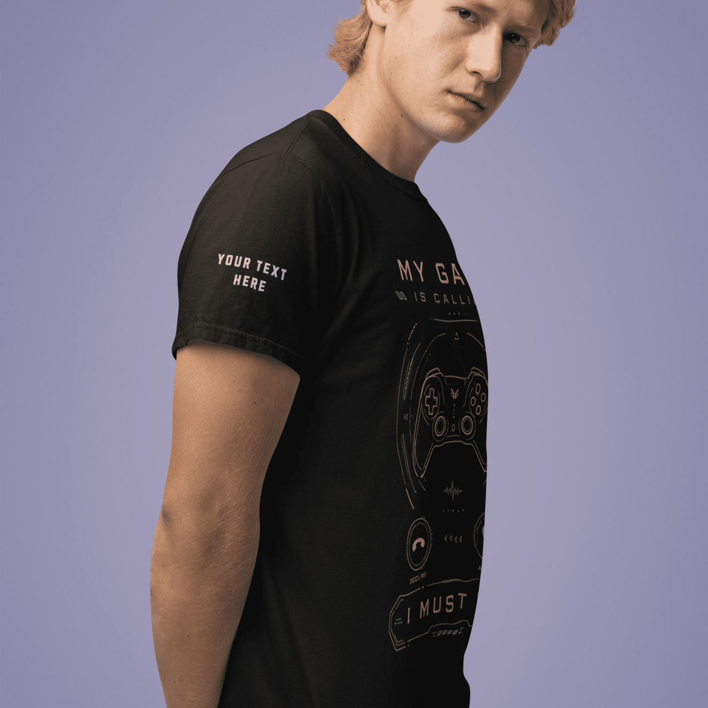 Angled front view of My Game Is Calling T-Shirt – I Must Go Gamer Mood worn by a model with hands behind the back