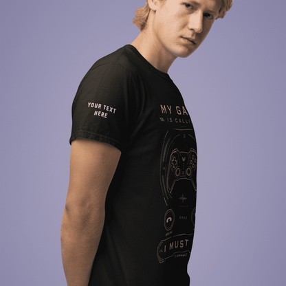 Angled front view of My Game Is Calling T-Shirt – I Must Go Gamer Mood worn by a model with hands behind the back