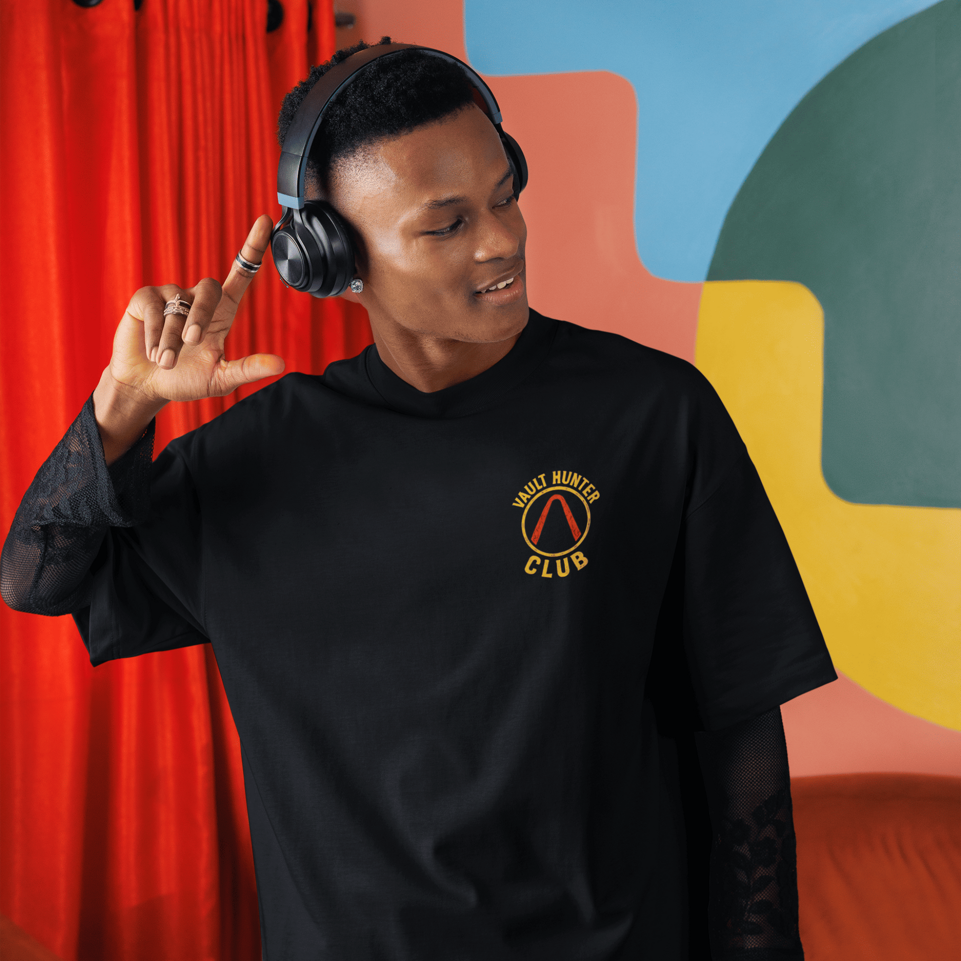 Person wearing a black sweatshirt with a logo in a colorful room