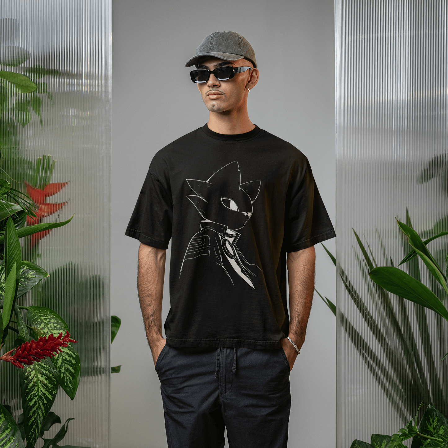 Full-body lifestyle image of a male model wearing the black Nine Sols T-Shirt – Silent Resolve Taopunk Portrait indoors with tropical plants.