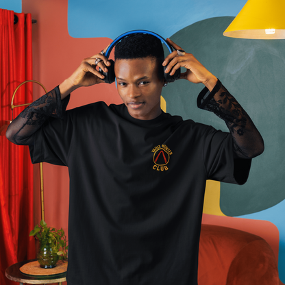 Person wearing a black shirt with a logo in a colorful room