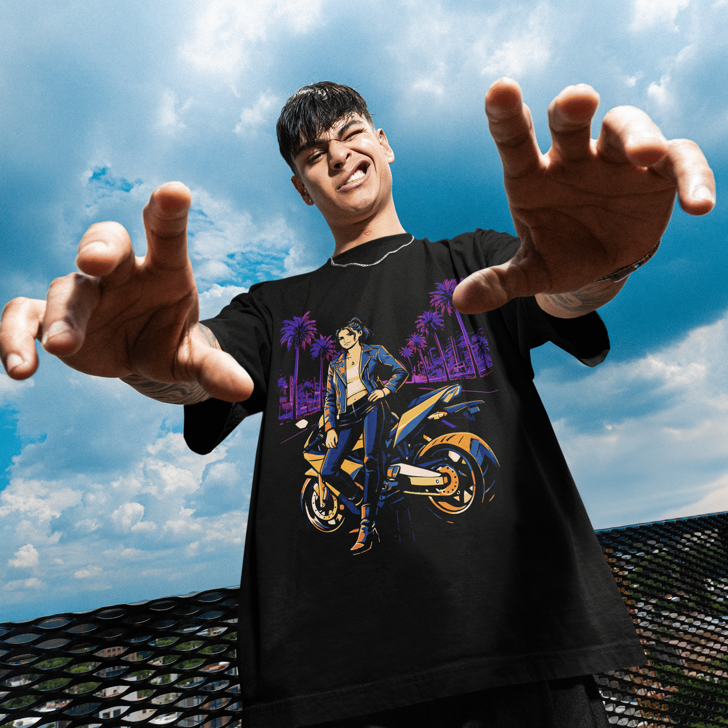 Person wearing a black t-shirt with a graphic design, standing against a blue sky.