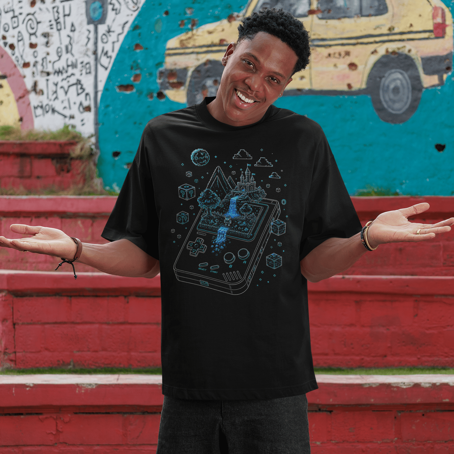 Front view of Handheld Pixel World Gamer T-Shirt with Pixel Adventure Art worn by a smiling model outdoors