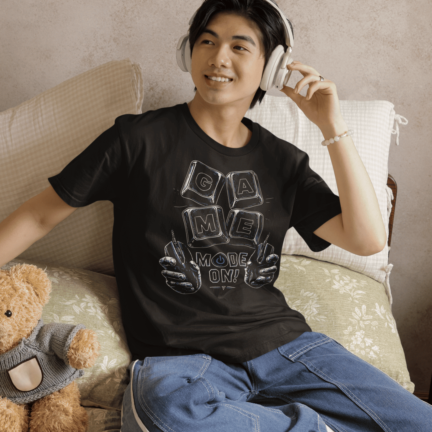 Male gamer sitting on a bed in Game Mode On T-Shirt with setup night artwork in a relaxed gaming atmosphere.