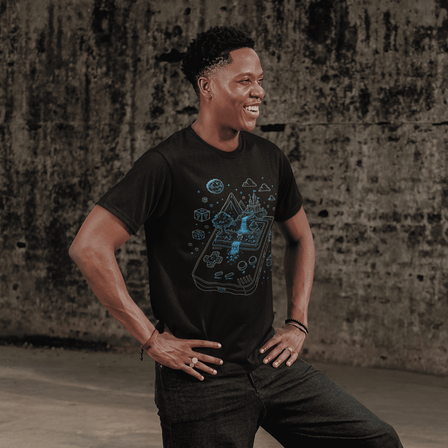 Full body view of Handheld Pixel World Gamer T-Shirt with Pixel Adventure Art worn by a model on concrete steps