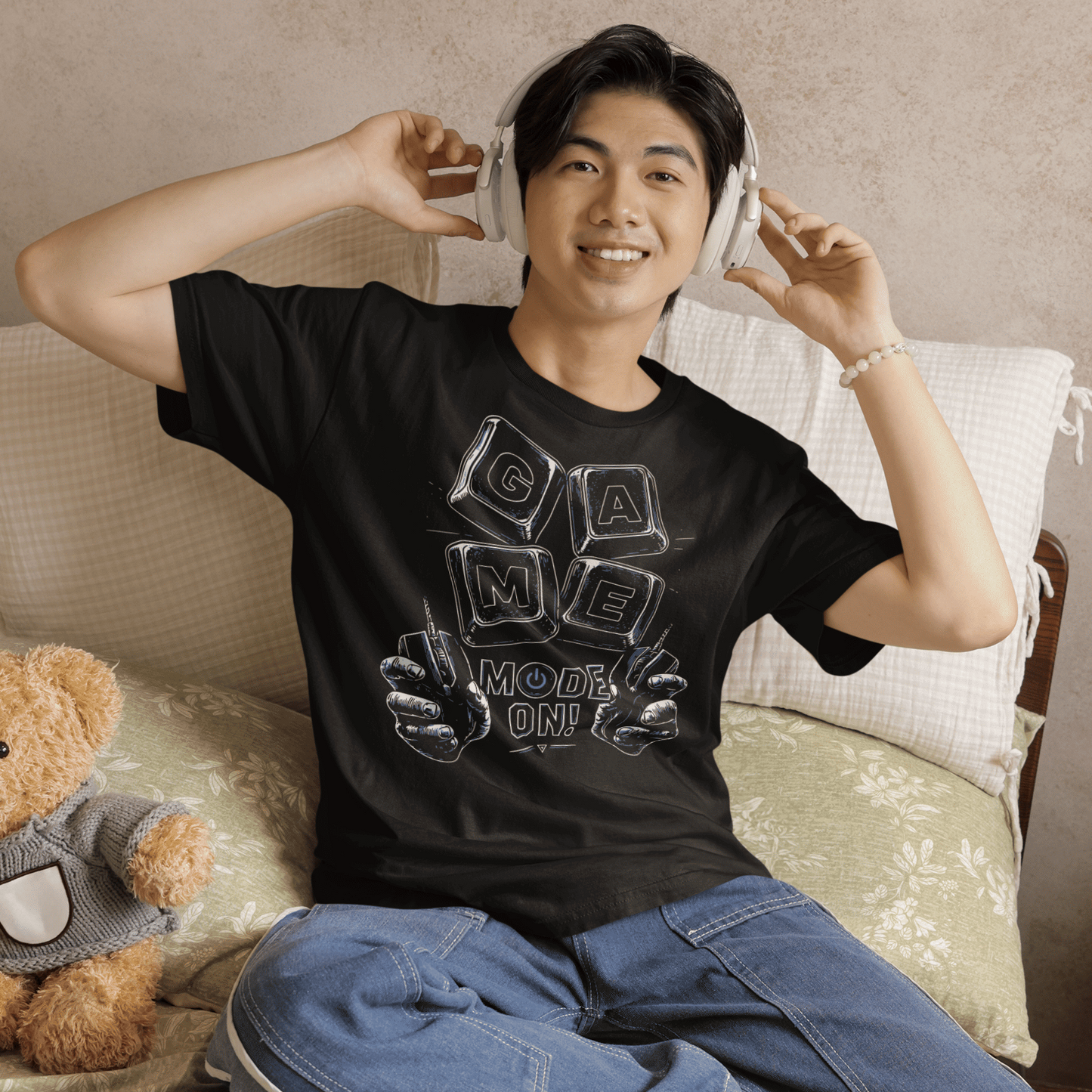 Smiling male gamer wearing Game Mode On T-Shirt with setup-inspired graphic during a cozy gaming night.
