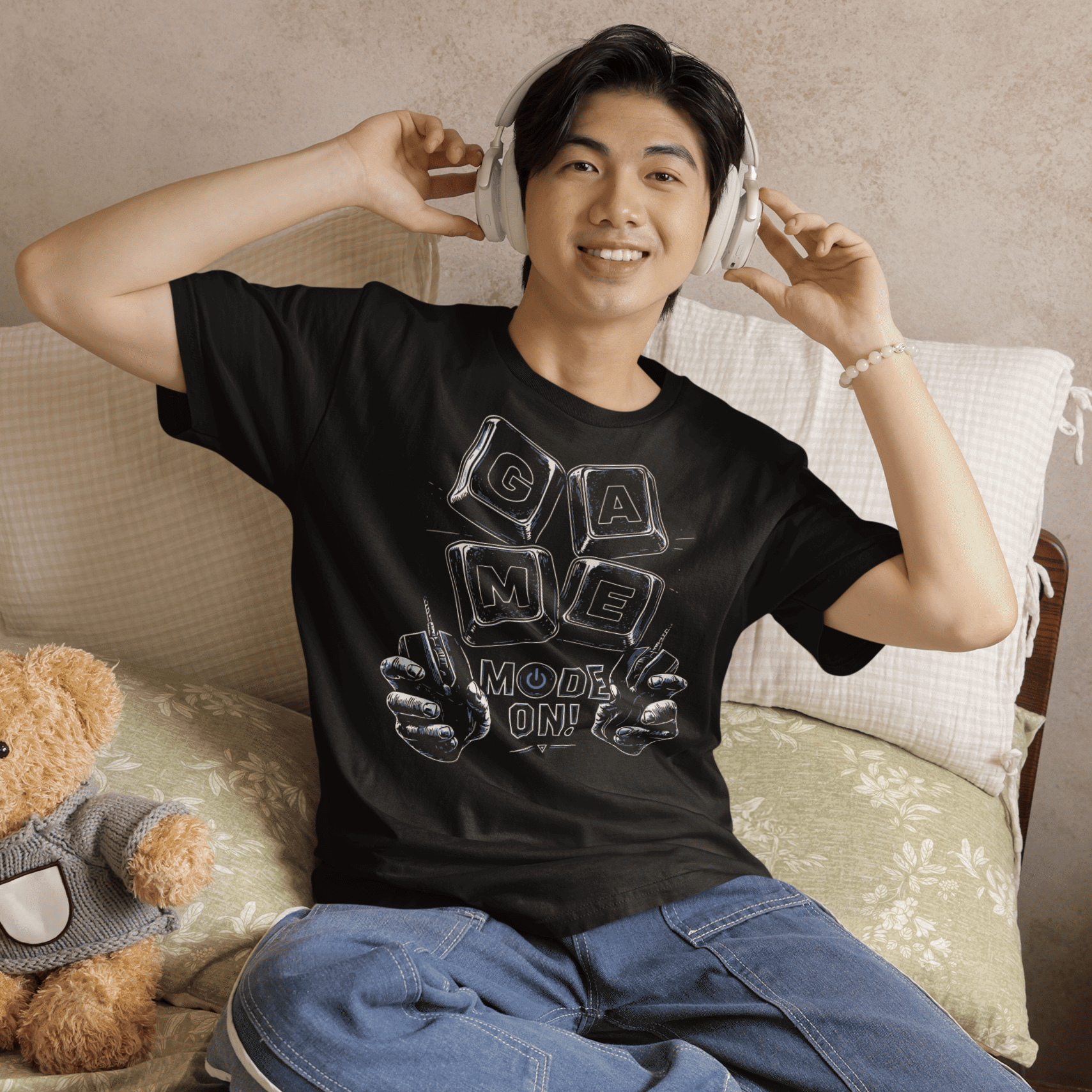 Smiling male gamer wearing Game Mode On T-Shirt with setup-inspired graphic during a cozy gaming night.
