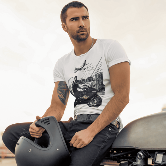 Man sitting on a motorcycle holding a helmet, wearing a white t-shirt with a graphic design.