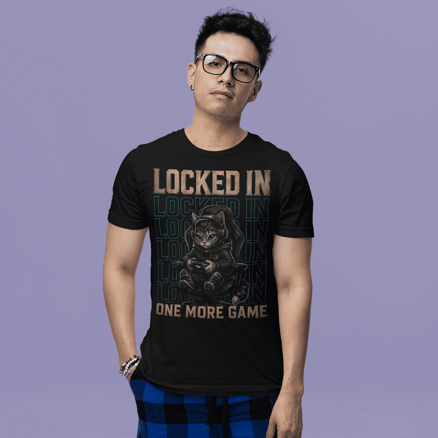 Male model wearing Locked In Cat Gamer T-Shirt with one more game graphic against a purple studio background.