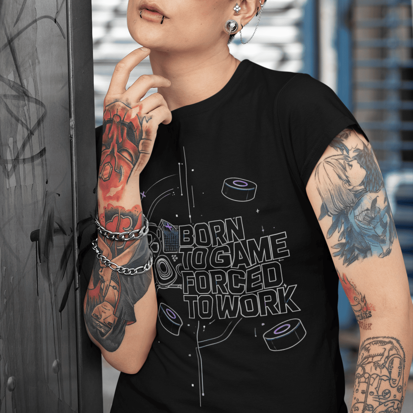 Person wearing a black sleeveless shirt with text and graphics, standing against an urban background.