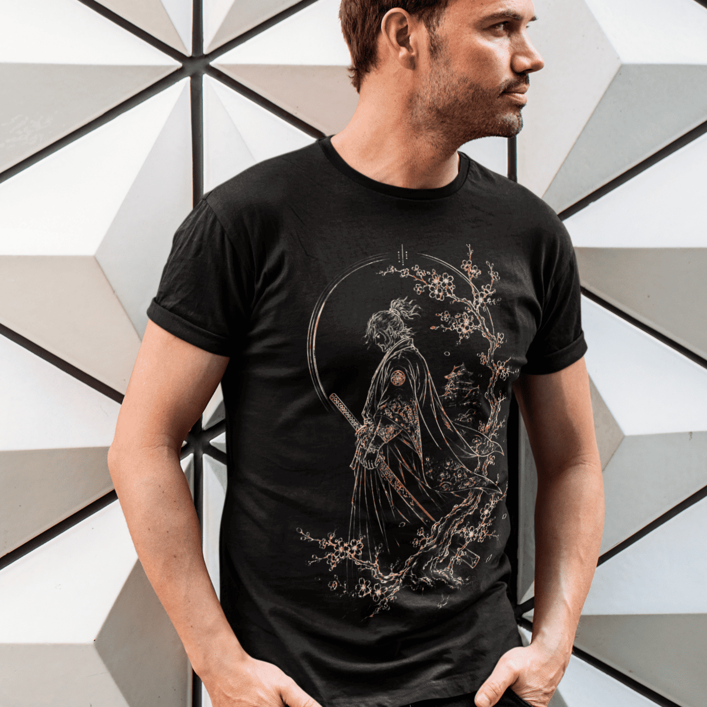 Male model posing in Lone Samurai T-Shirt with cherry blossom samurai graphic beside modern geometric architecture.