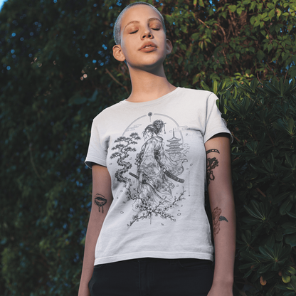 Female model in Kimono Samurai T-Shirt with detailed warrior artwork standing in a leafy outdoor setting.