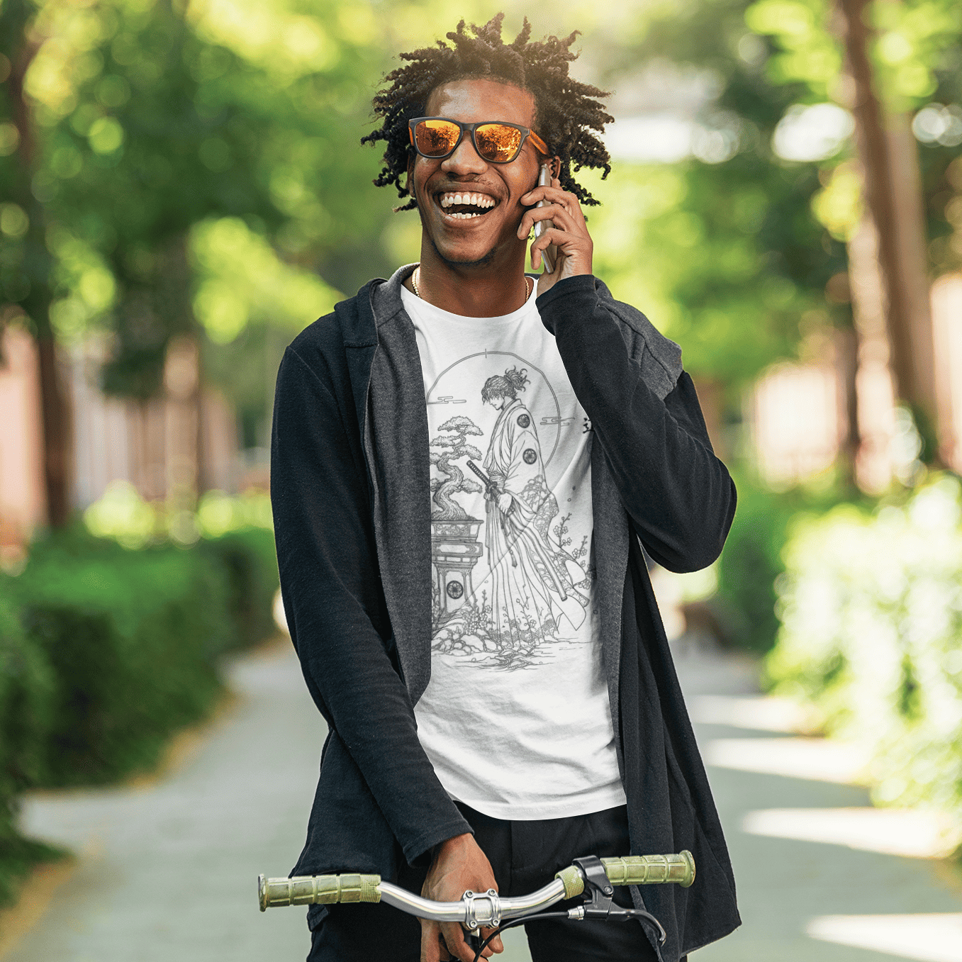 Male model walking with a bicycle in Bonsai Samurai T-Shirt featuring quiet warrior artwork in a green park.