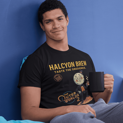 Person wearing a 'Halcyon Brew' t-shirt holding a mug against a blue wall.