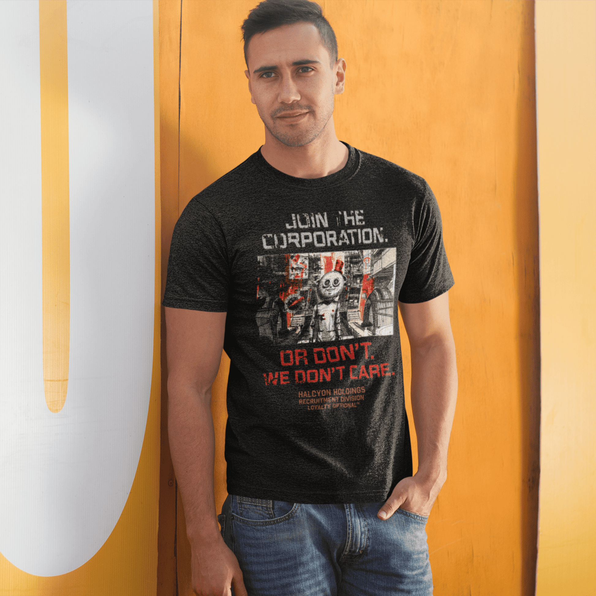 Man wearing a black t-shirt with graphic design and text, standing against a yellow wall.