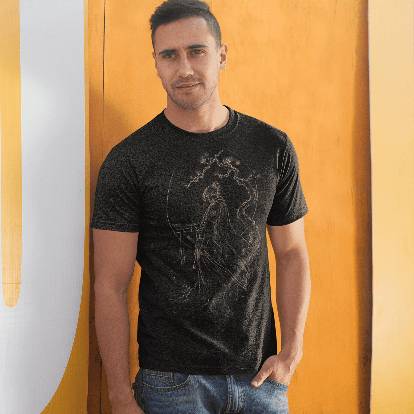 Male model posing in Torii Samurai T-Shirt with minimalist warrior gate design against a modern yellow wall.