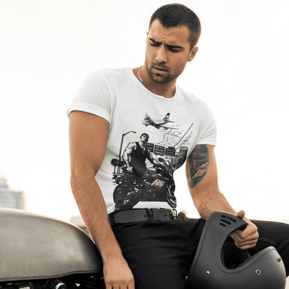 Man sitting on a motorcycle holding a helmet, wearing a graphic t-shirt.