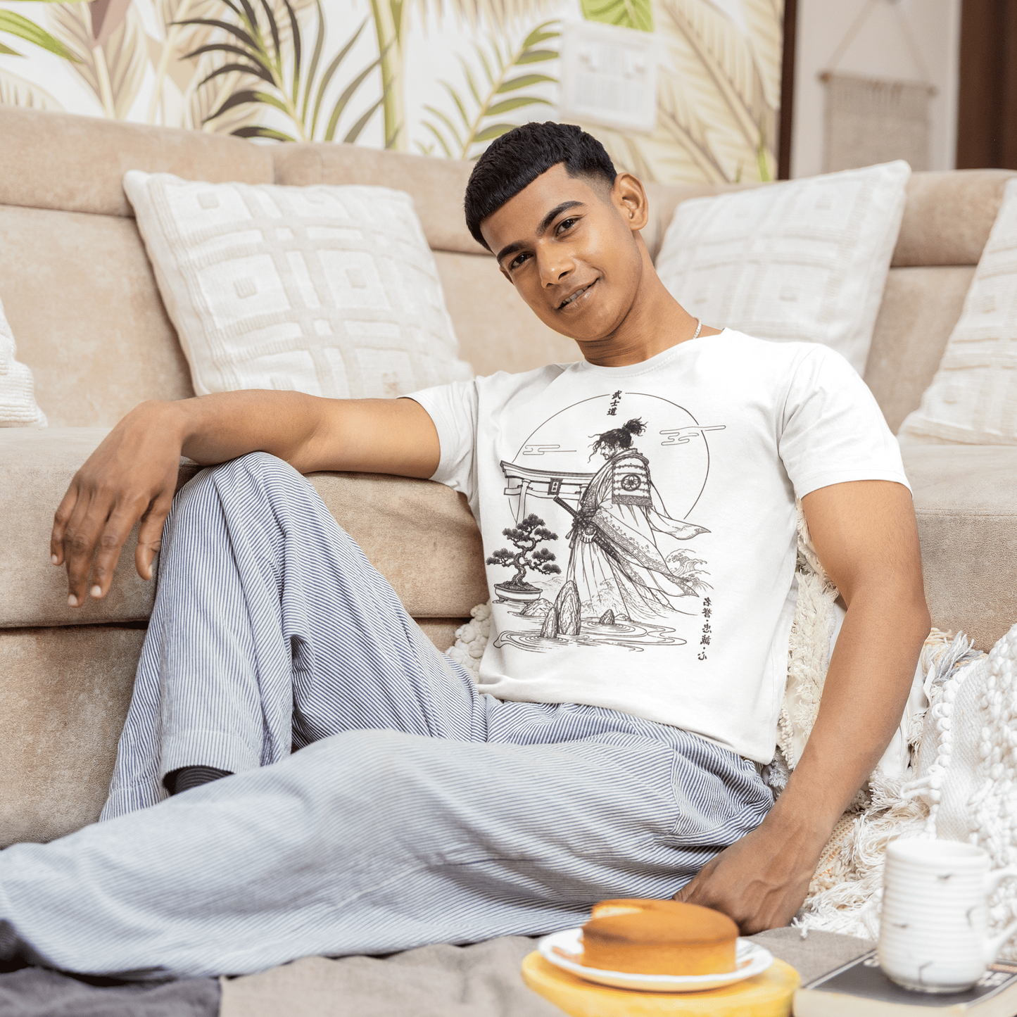 Male model posing playfully in Bushido Samurai T-Shirt with warrior garden artwork against a carved wood wall.