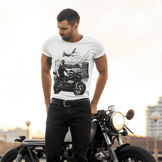 Man wearing a white t-shirt with a graphic design, standing next to a motorcycle.
