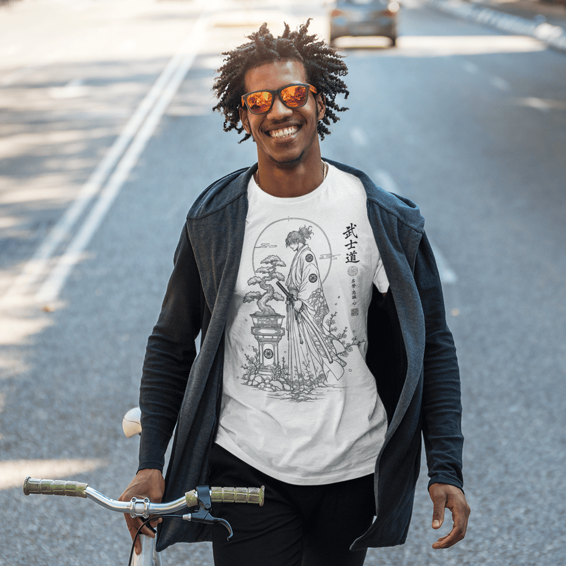 Male model standing with a bicycle in Bonsai Samurai T-Shirt featuring Bushido warrior artwork on a city street.
