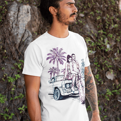 Man wearing a white t-shirt with a graphic design of a car and palm trees, standing against a natural background.