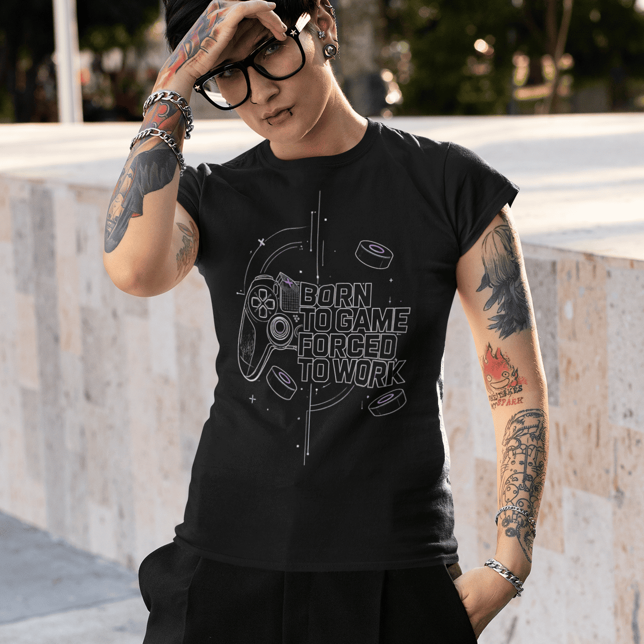 Outdoor view of Born to Game Forced to Work Gamer T-Shirt worn by a model shading their eyes