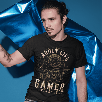 Male model wearing Adult Life Gamer Mindset T-Shirt with retro gaming graphic in a bold blue studio scene.
