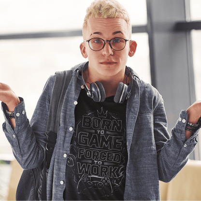 Front view of Born to Game Forced to Work T-Shirt – Headset Gamer Mode worn with headphones and shrug pose