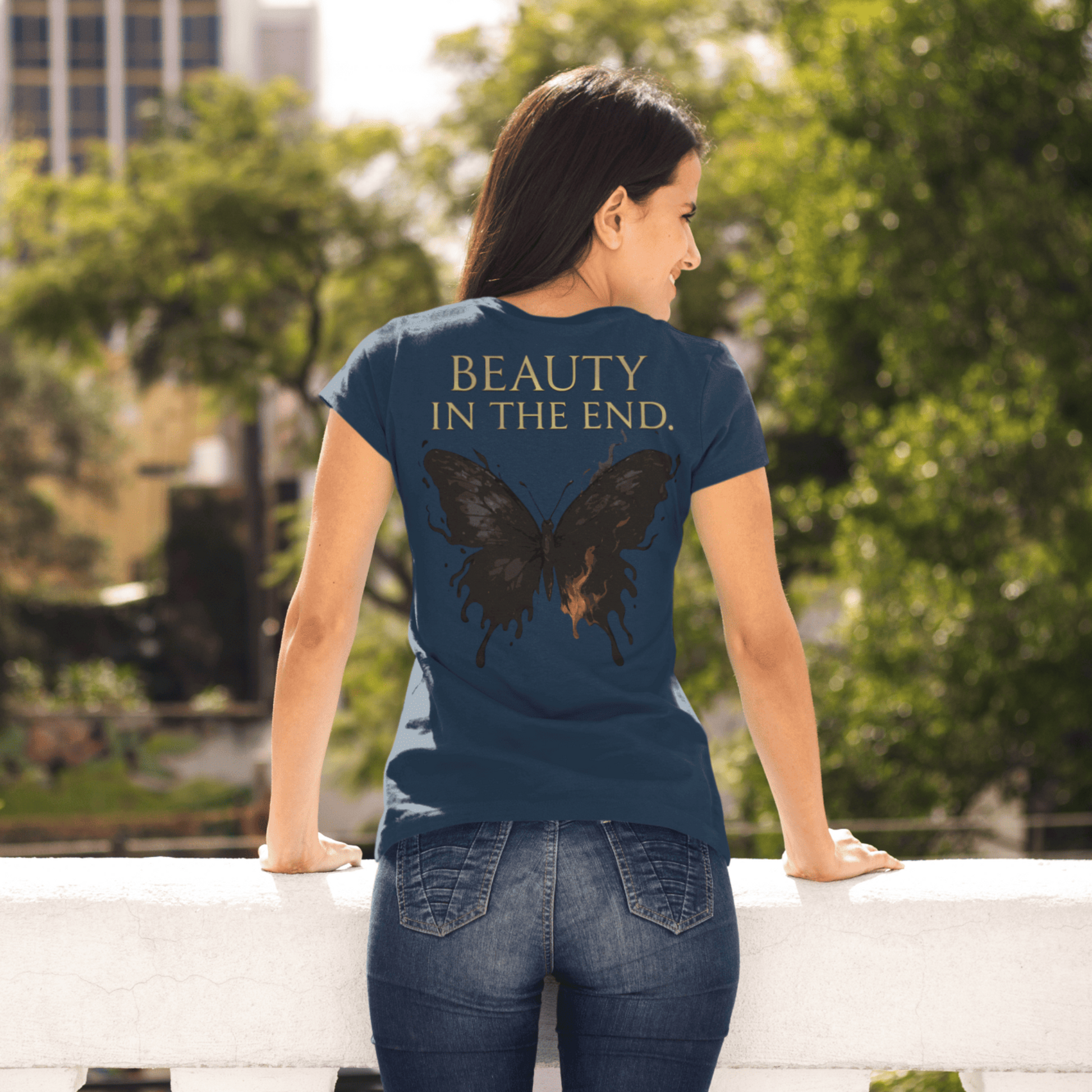 Person wearing a blue t-shirt with a butterfly design and text in an outdoor setting