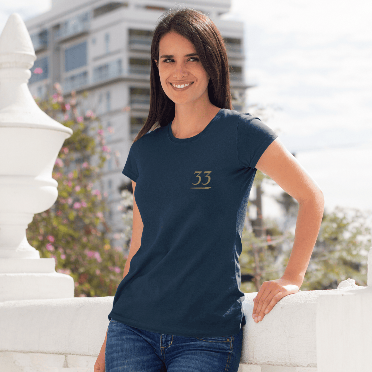 Woman wearing a navy blue t-shirt with the number 33, standing outdoors.