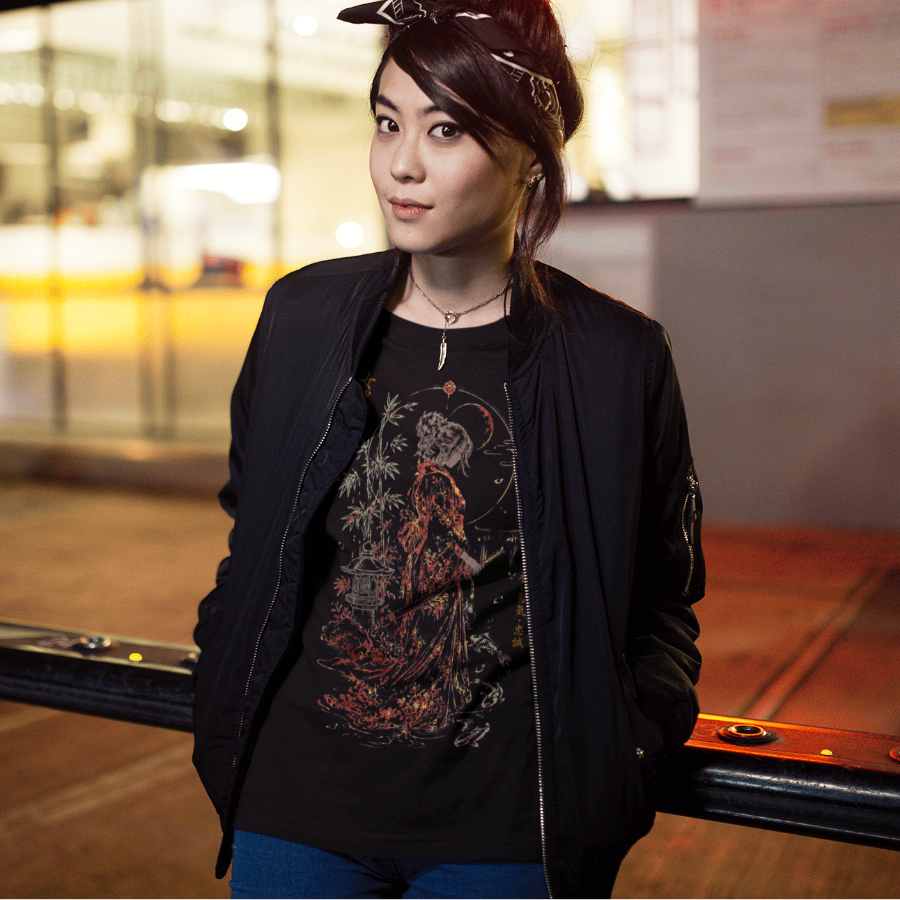 Female model posing in Female Samurai T-Shirt with warrior artwork in a warm urban evening setting.