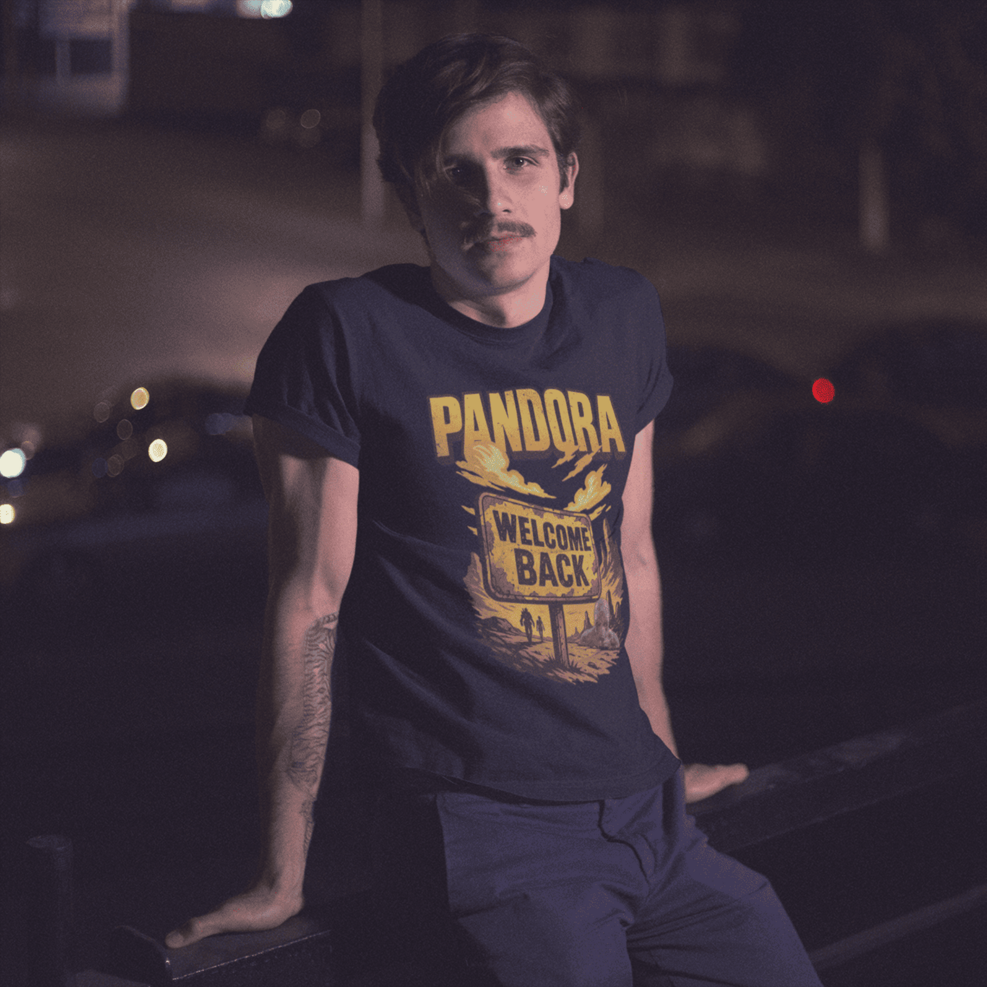 Man wearing a Pandora t-shirt in a dark setting with cars in the background