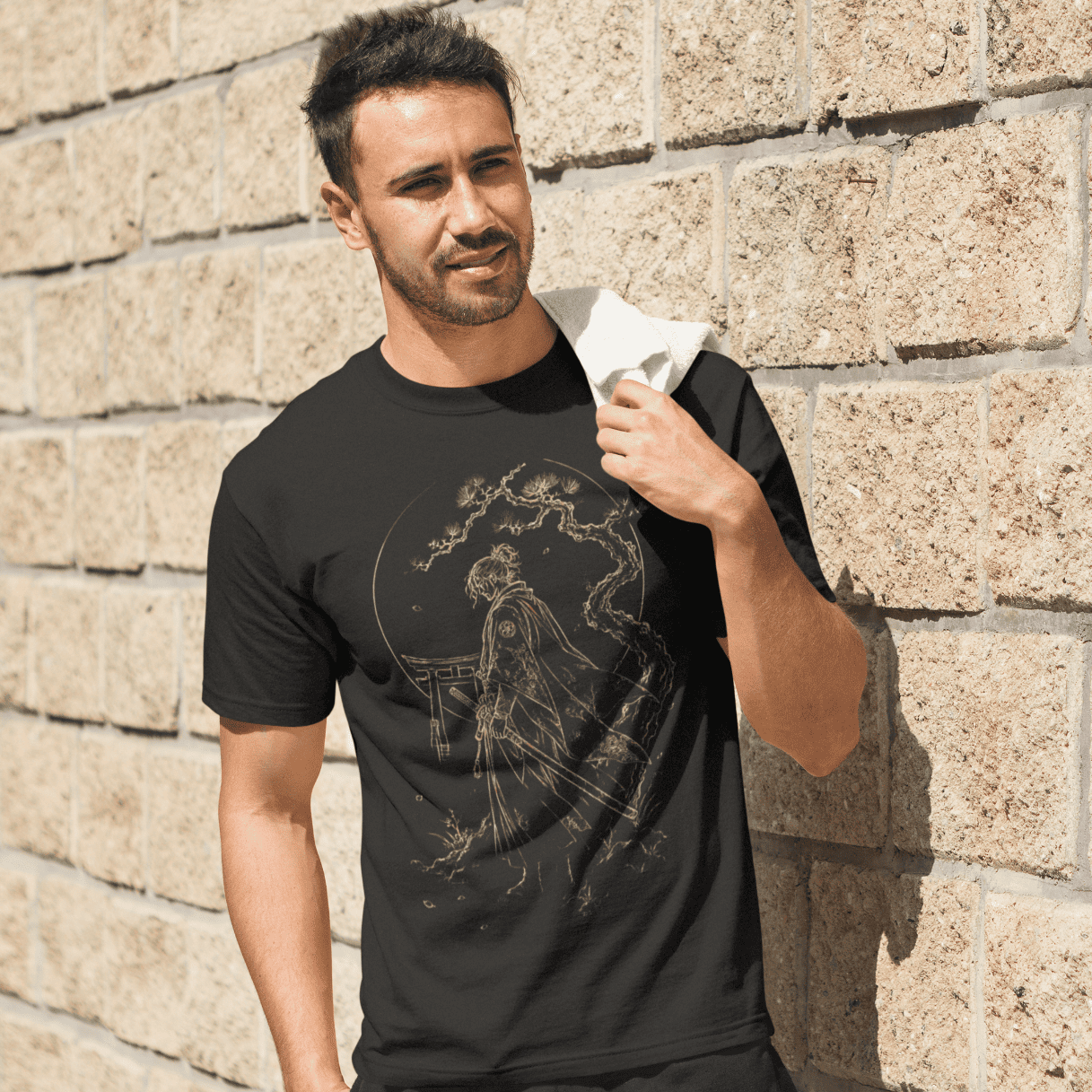 Male model wearing Torii Samurai T-Shirt with minimalist samurai gate artwork in a modern outdoor scene.
